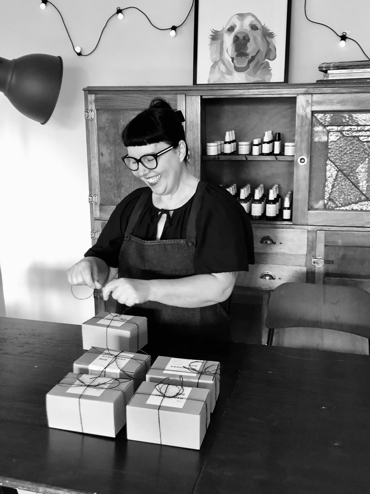 Founder of Charlie & I in apothecary studio smiling wrapping customer orders in the Gippsland Hills Victoria Australia